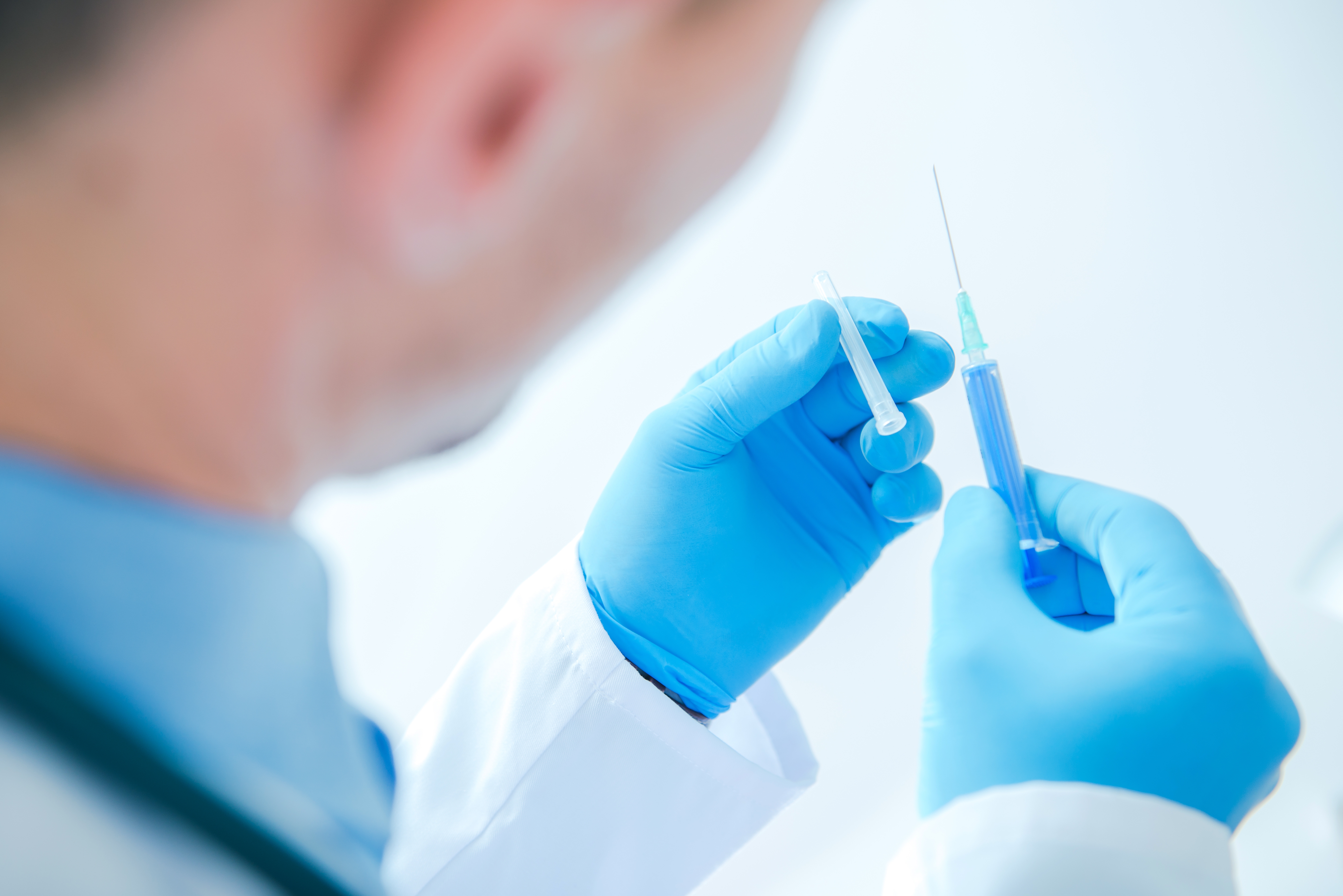 perspective view of doctor manipulating a syringe