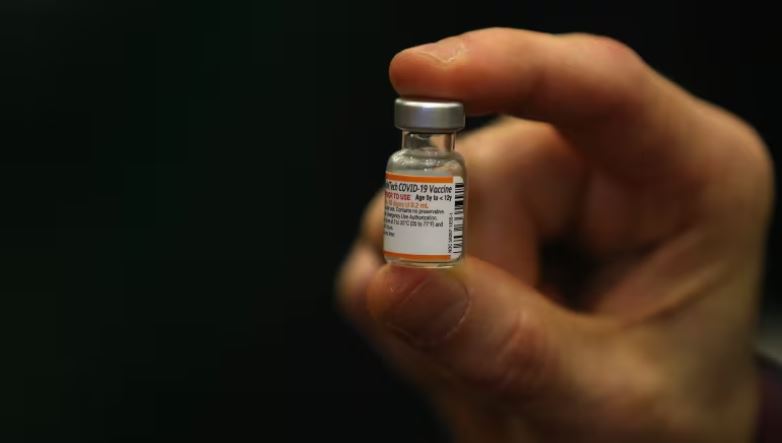 hand holding a vial of vaccine 