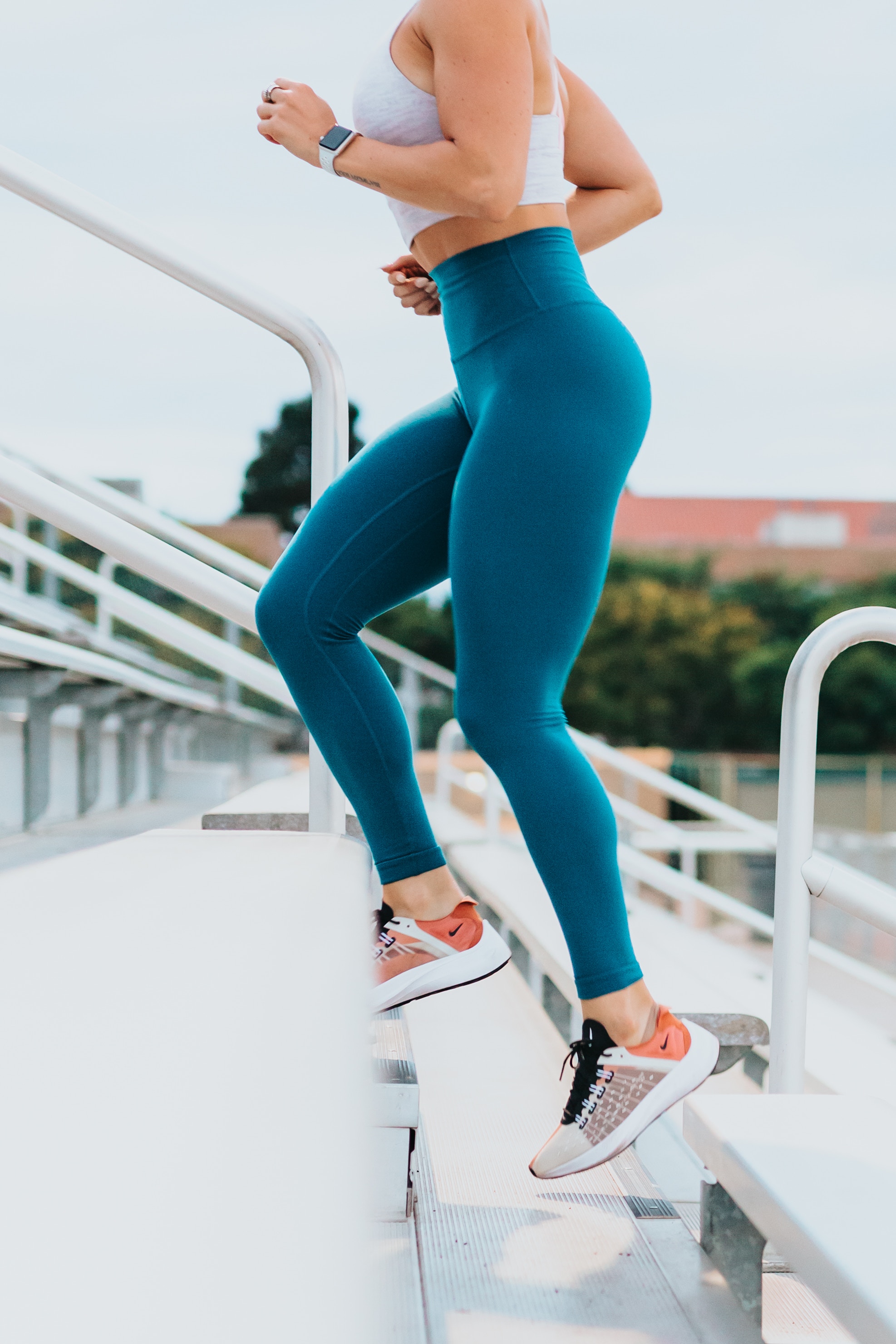 female running up stairs of a stands in a track and field setting
