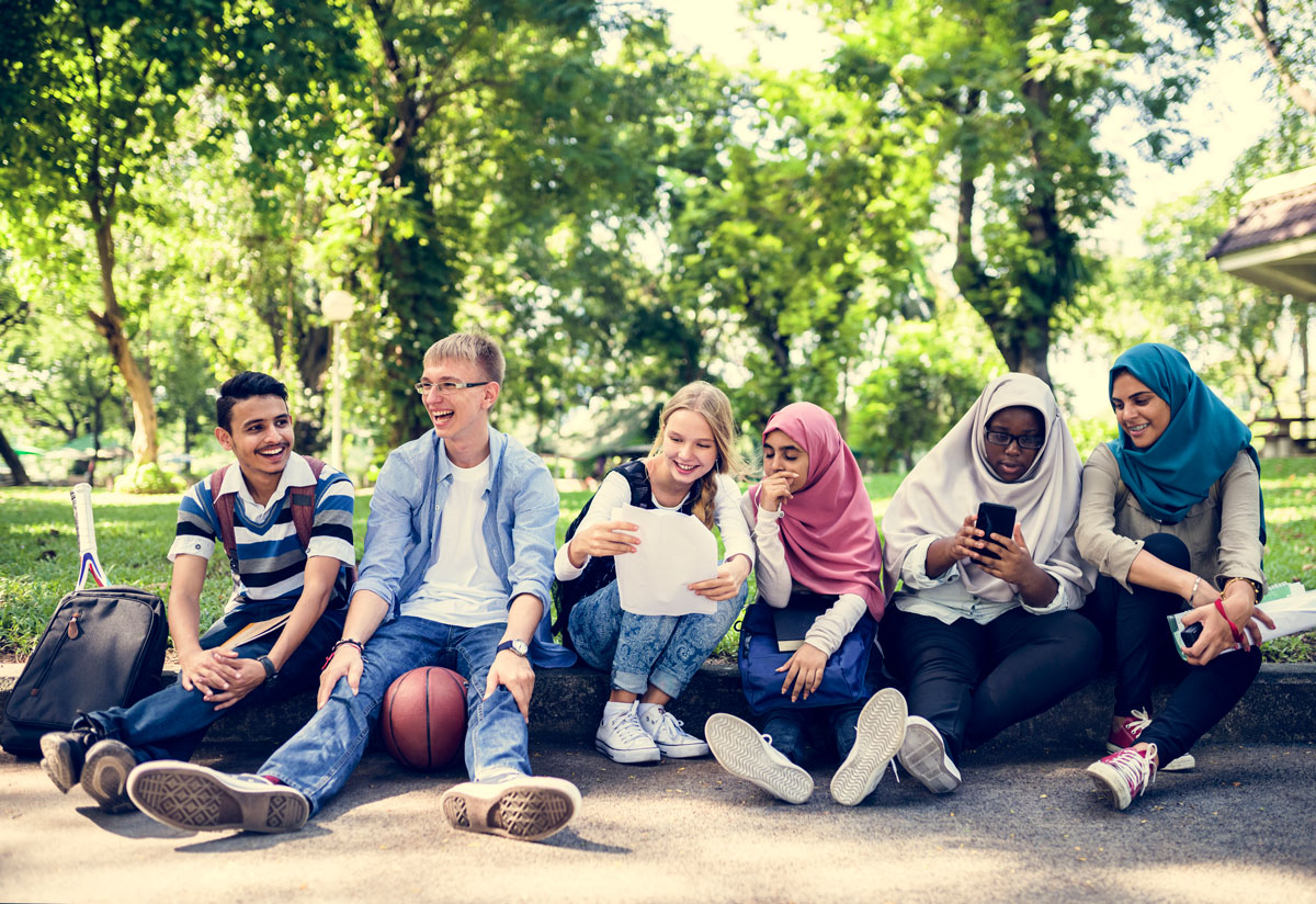 group of young females of different nationalities sitting together and enjoying their time at a park