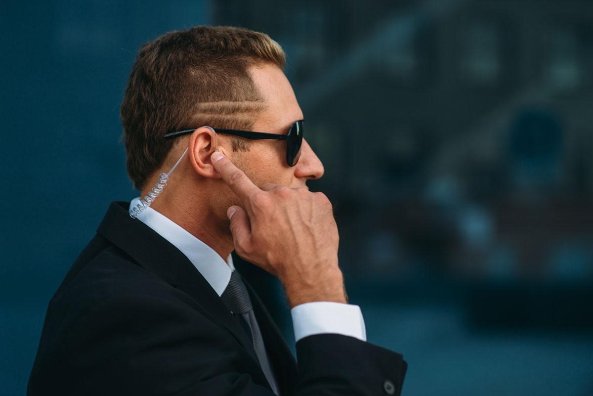 agent de sécurité avec un doigt dans l'oreille 