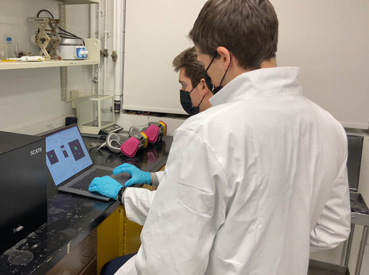  Alex Boukin and Ari Forman work in a lab  
