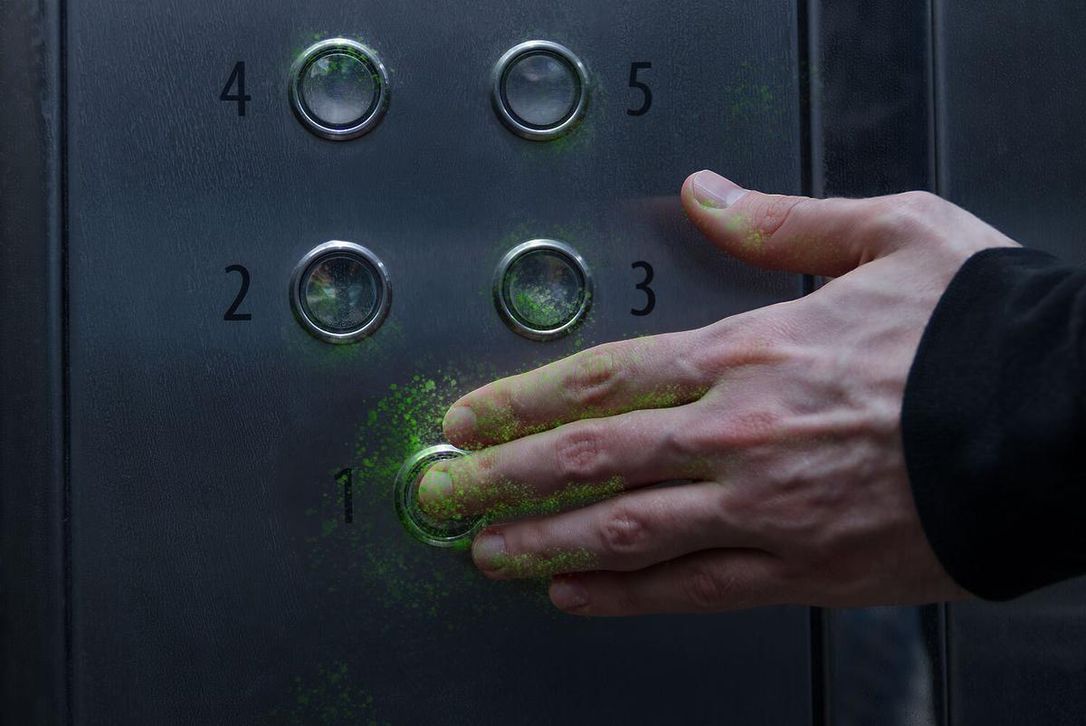 hand pushing elevator button getting contaminated by bright green virus particles 