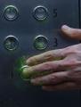 hand pushing elevator button getting contaminated by bright green virus particles